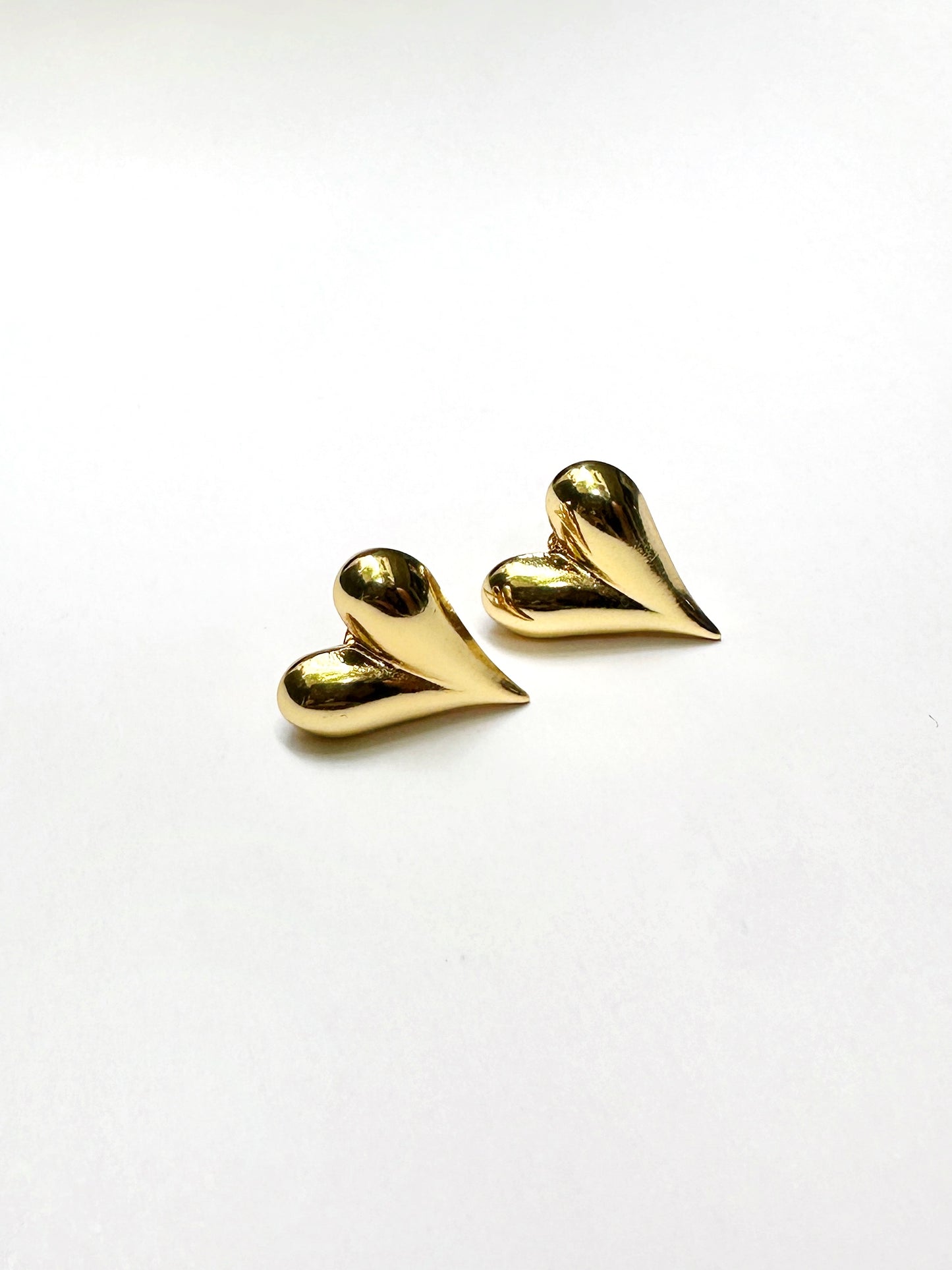 Gold-tone stainless steel heart stud earrings on white background