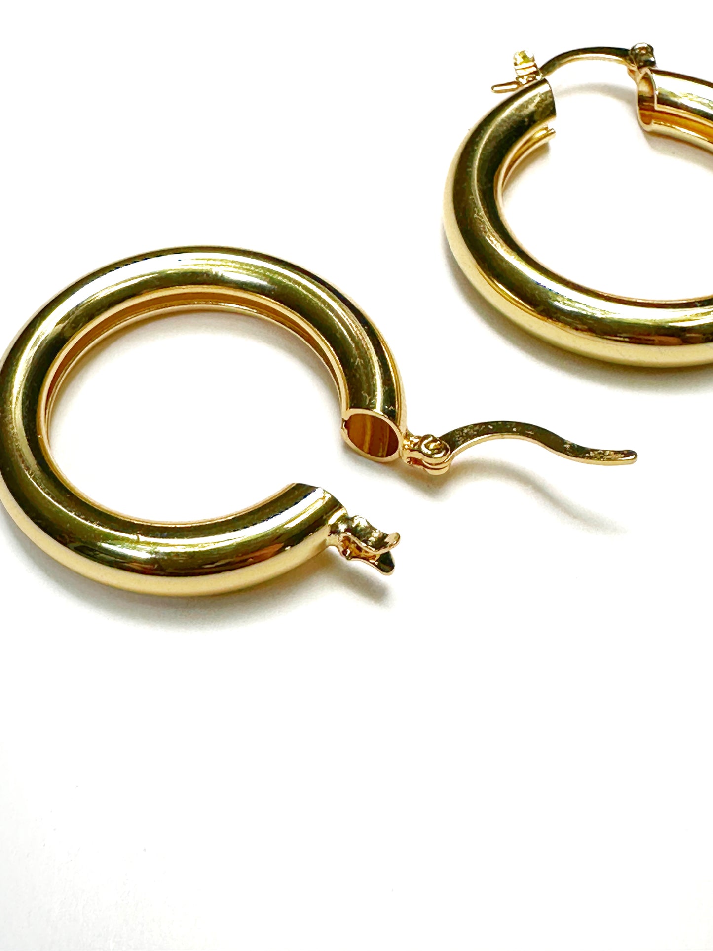 Close-up of gold chunky hoop earrings with stainless steel clasp and latch back design