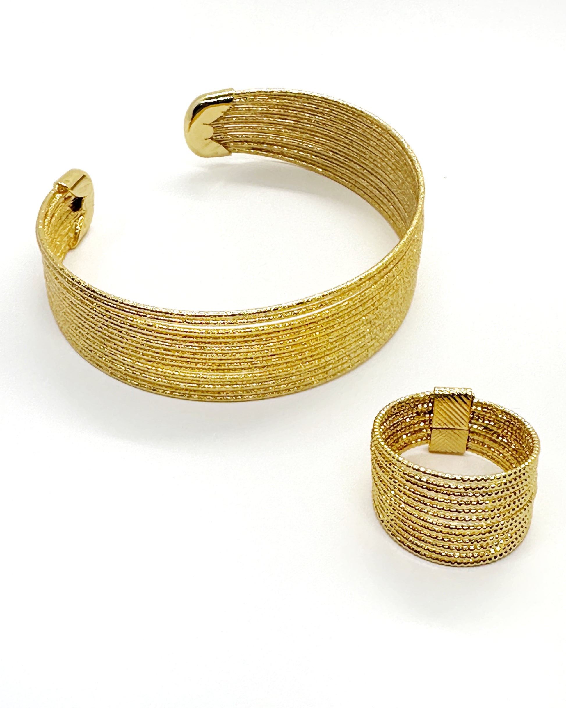 Layered gold strand cuff and ring set on white background