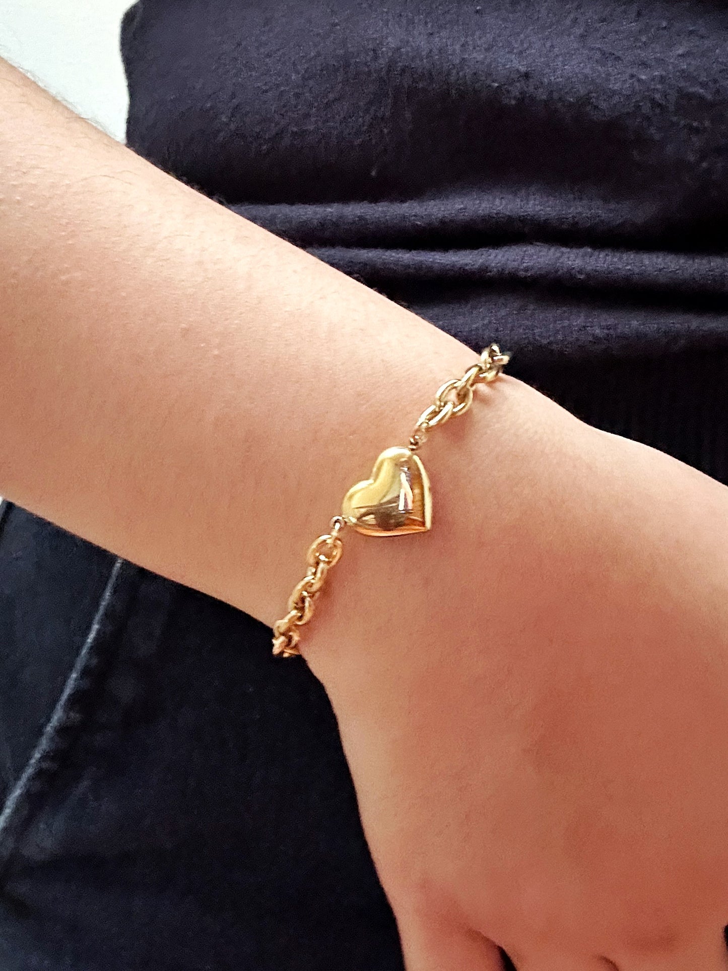 Chunky gold heart bracelet styled on wrist – bold and feminine accessory