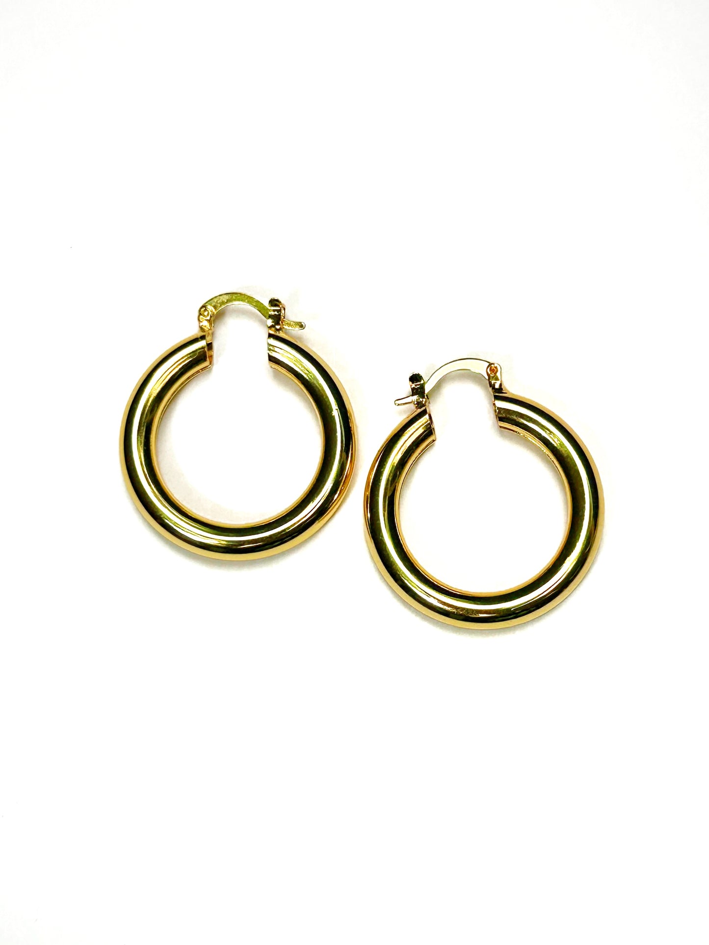 Pair of gold stainless steel chunky hoop earrings flat-laid on a white background