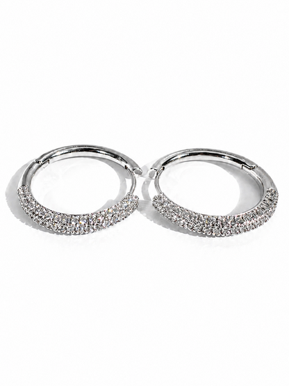 Pair of silver hoop earrings with embedded stones on a white background