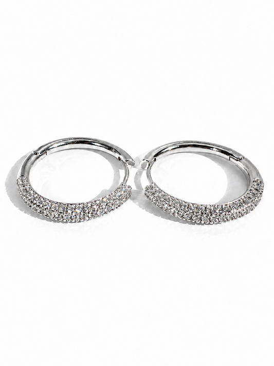 Pair of silver hoop earrings with embedded stones on a white background