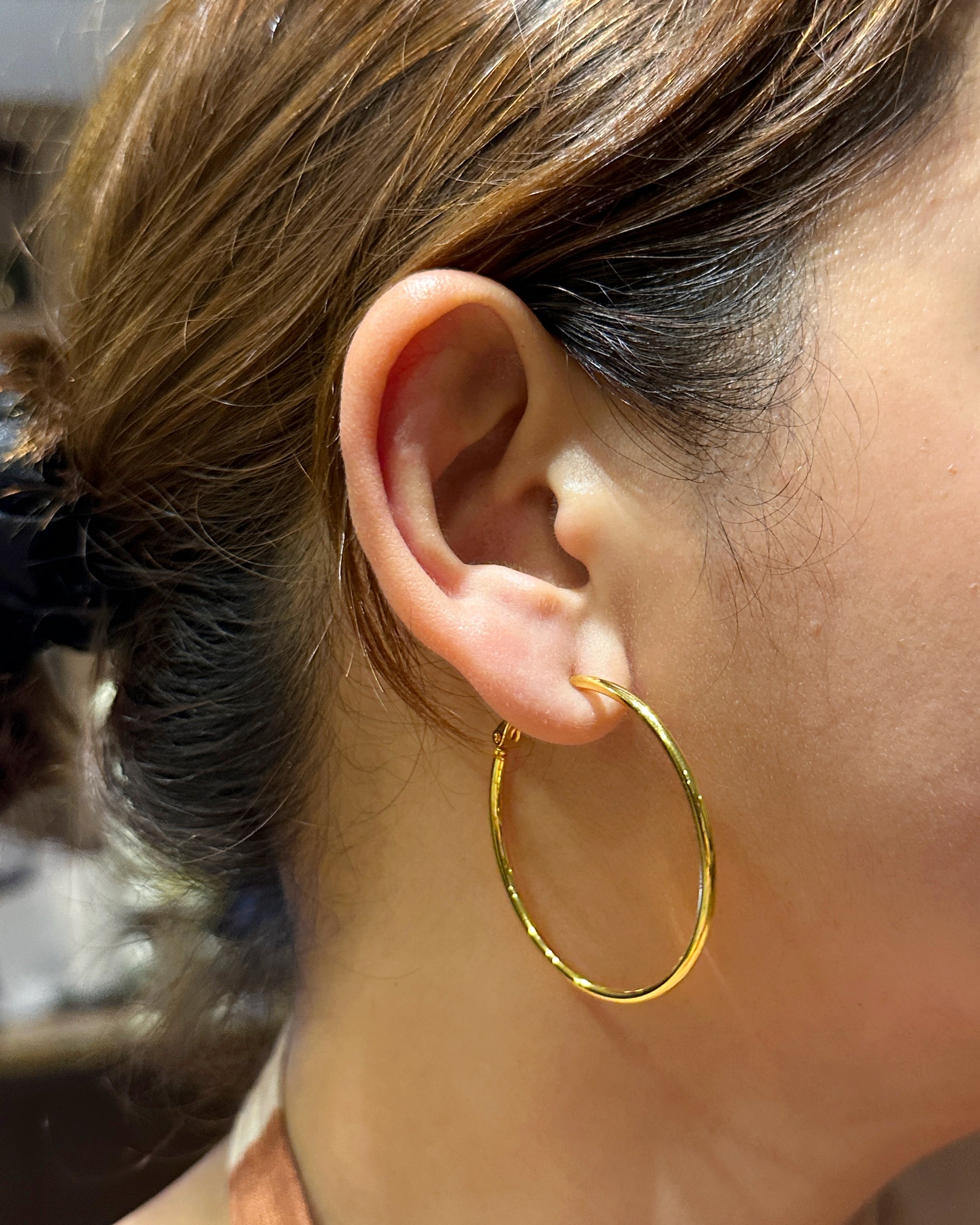 close up model wearing retro inspired thin gold hoop earrings stainless steel hoops