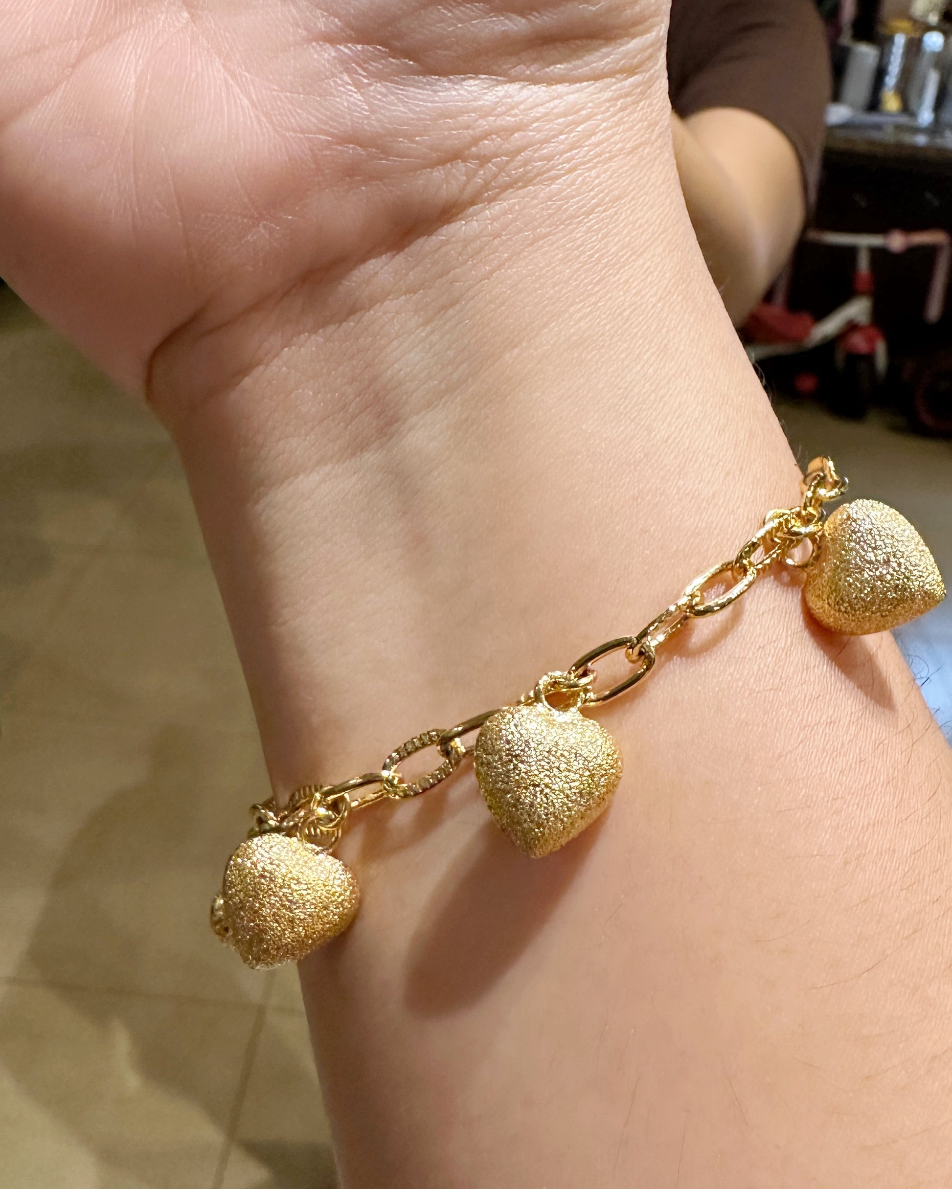 Frosted heart charm link bracelet worn on wrist