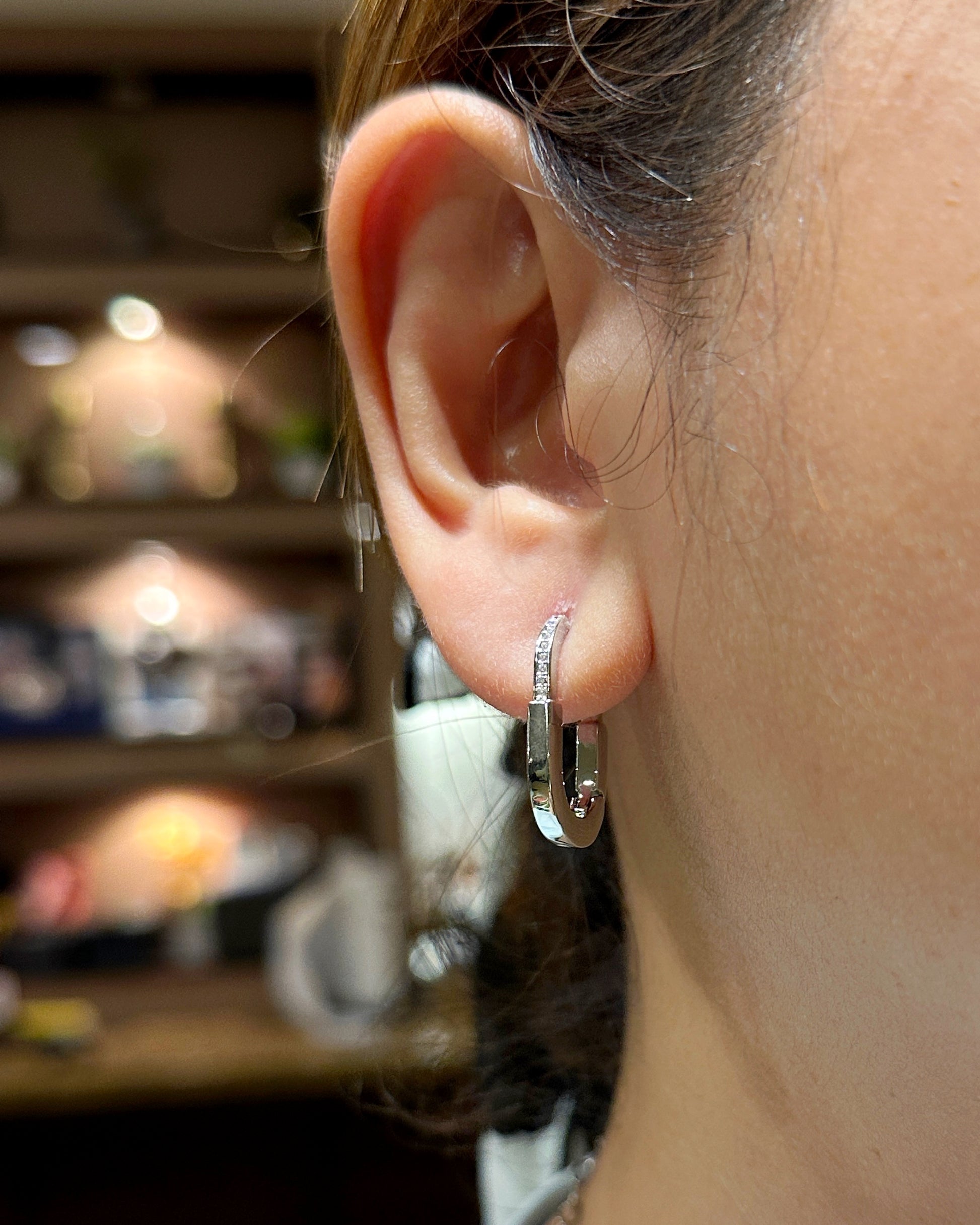 Close-up of zirconia huggie earrings worn on ear showcasing sparkle and fit