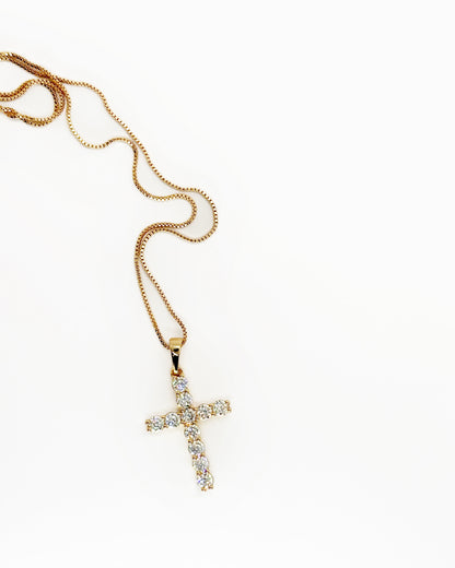 Gold zirconia cross pendant necklace on white background