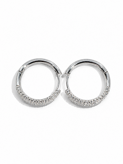 Pair of silver hoop earrings with small stones on a white background