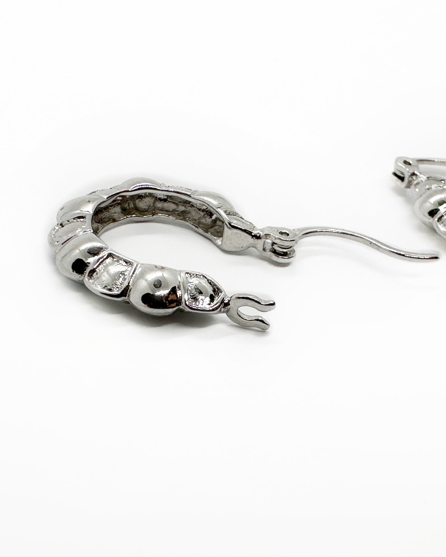 Side profile of the sculpted hoop earrings highlighting the hinged clasp mechanism