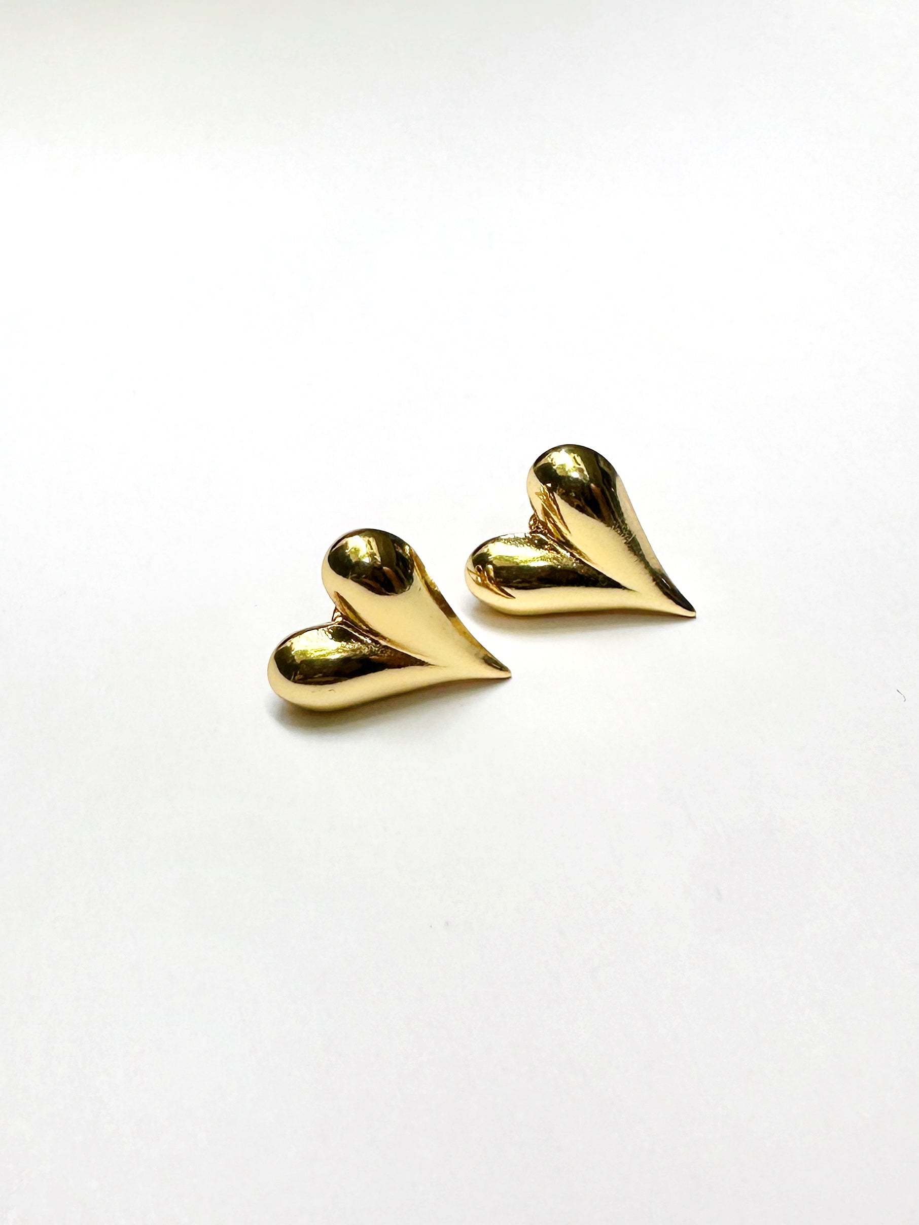 Gold-tone stainless steel heart stud earrings on white background