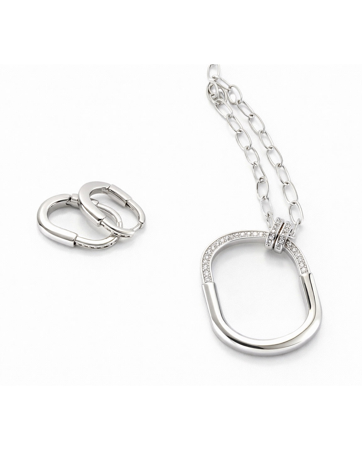 Full jewelry set with oval pendant necklace and huggie earrings clean flat lay