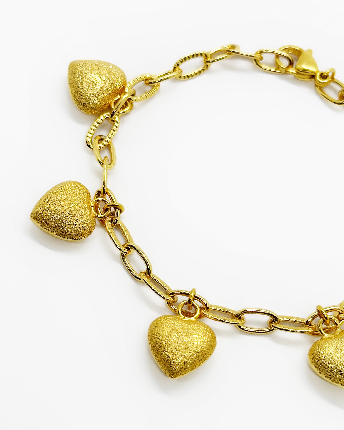 Close-up of frosted heart charm showing matte gold texture