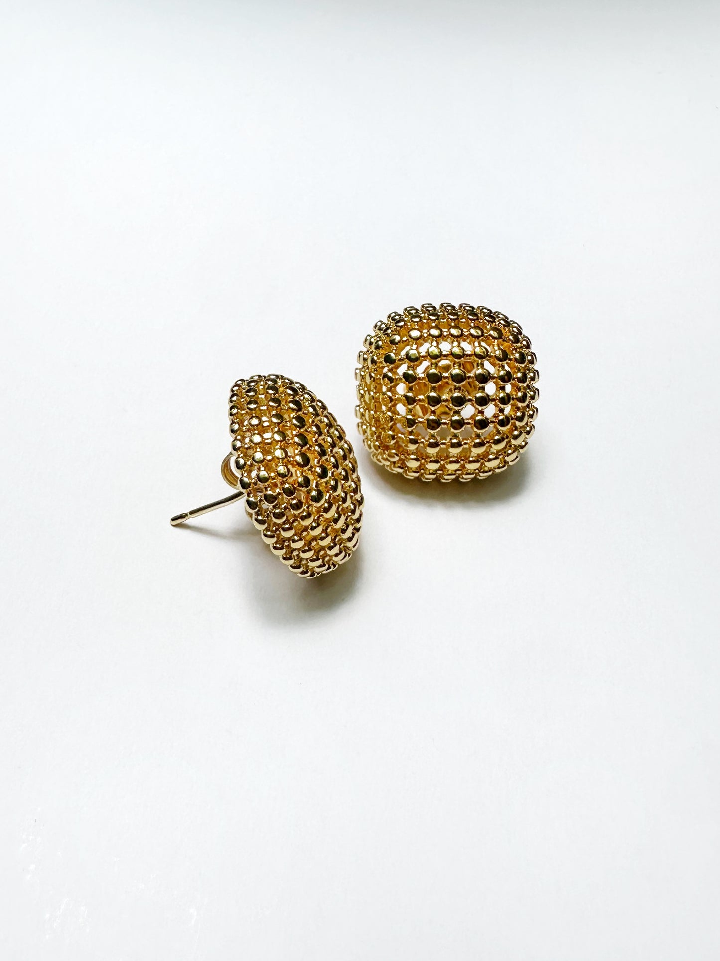 Flat-lay of gold mesh dome earrings with visible stainless steel post