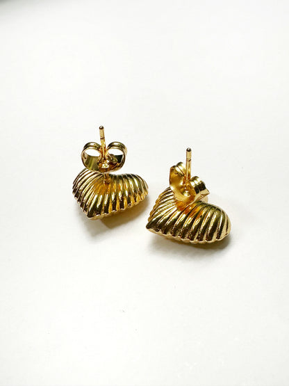 Flat lay showing back post of gold-tone ribbed heart earrings on white background