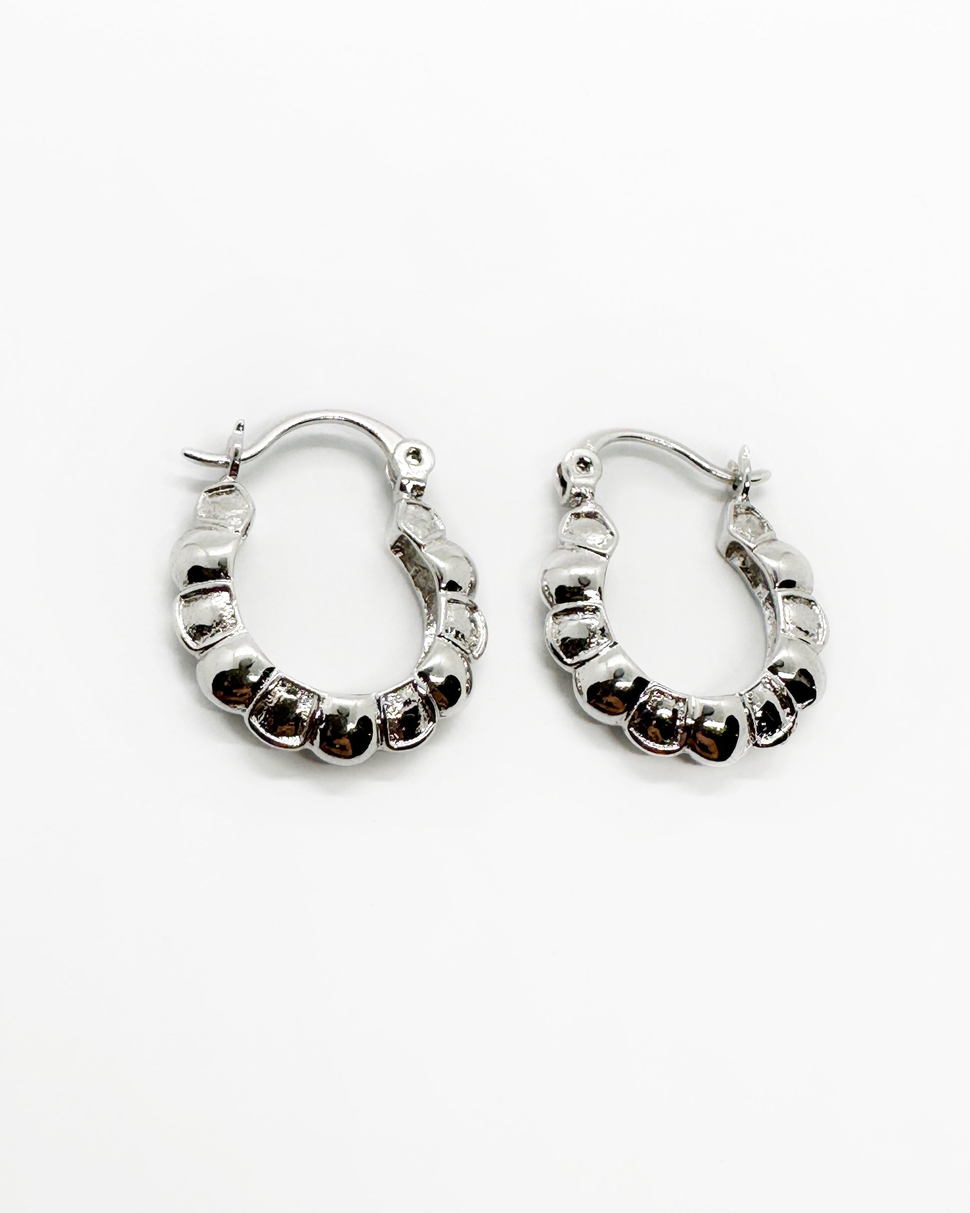 Pair of silver hoop earrings on a white background