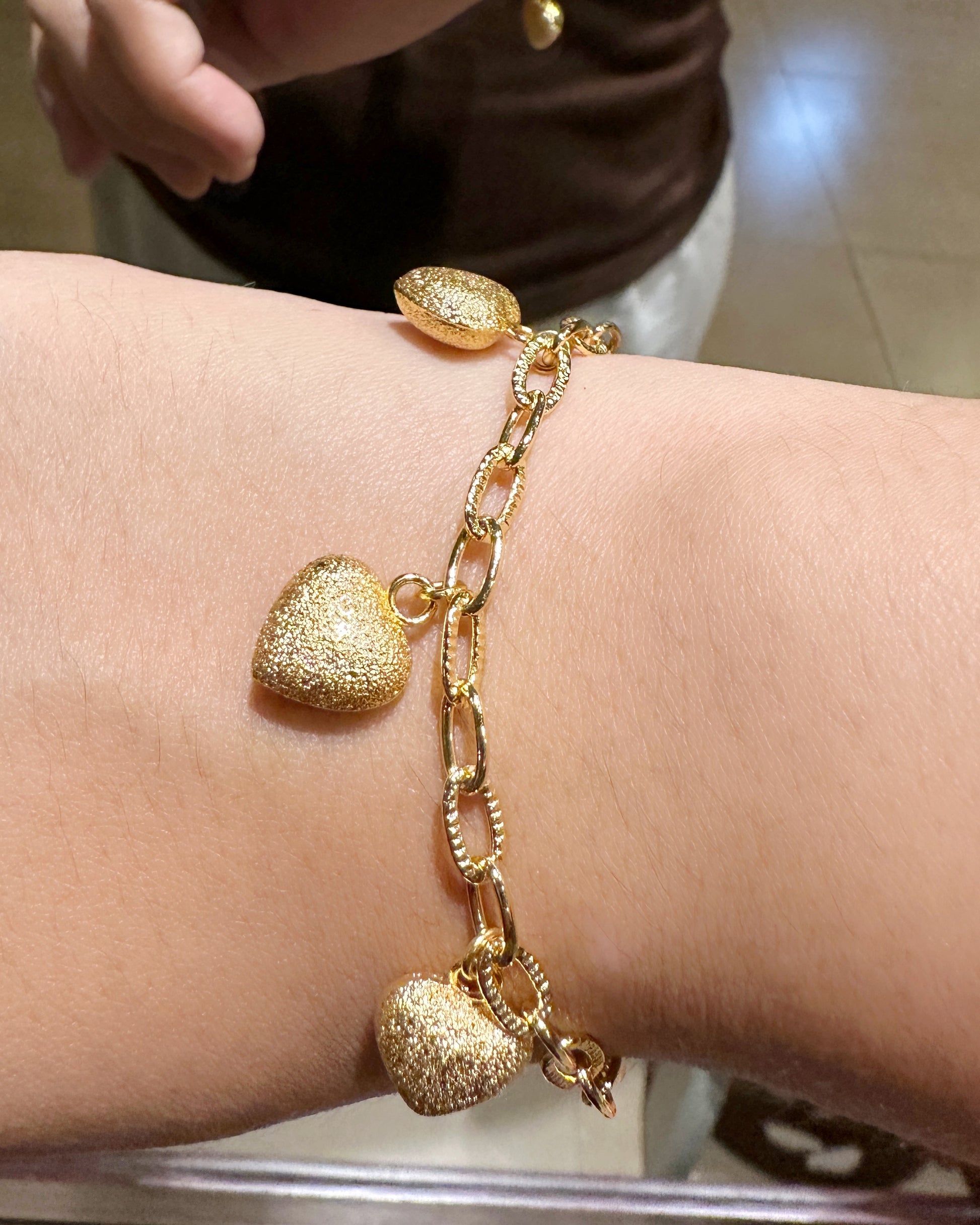 Lifestyle shot of frosted heart charm bracelet styled for everyday wear