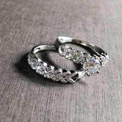 Two-piece white gold ring set with solitaire and braided design on flatlay