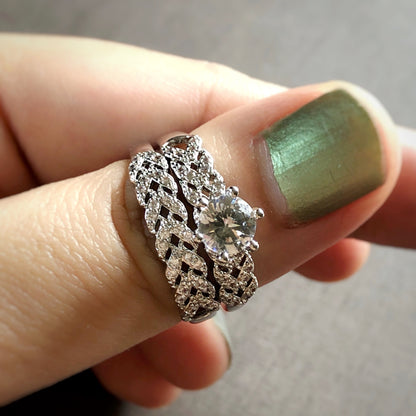 Close-up of braided zirconia ring set worn on finger with green polish